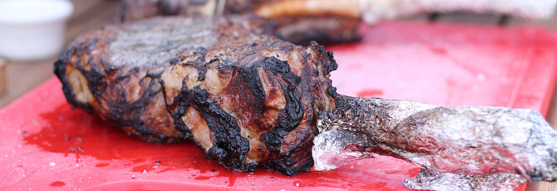 La cuisson de steak Tomahawk sur charbon de bois